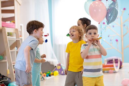 Children birthday party. Kids blow noisemaker hornsの写真素材