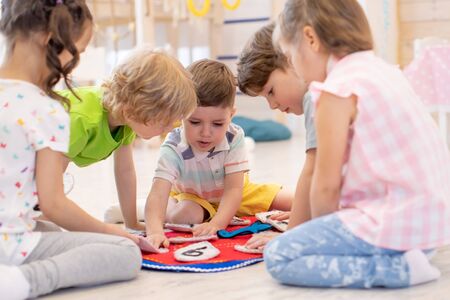Kids learning time on clock and set the hands and the digitals in the correct position. Candid children, real moment, authentic situationsの写真素材