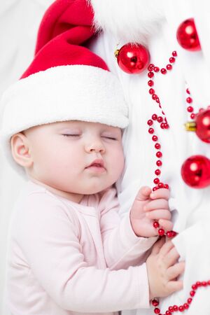 Sweet baby infant weared santa hat sleeping on whiteの写真素材