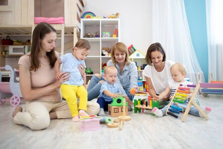 Happy parents and kids playing educational toys in playroomの写真素材