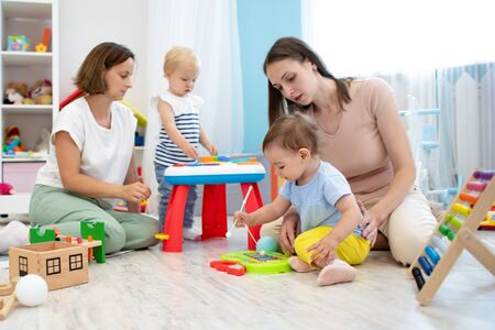 Little babies play in nursery. Developmental toys for preschool.の写真素材