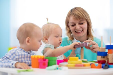 Little caucasian baby playing with Montessori toy in pre-schoolの写真素材