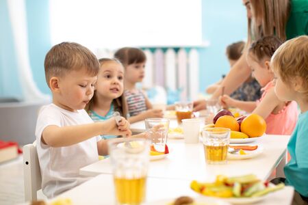 Kids eating in kindergarten or day care centreの写真素材