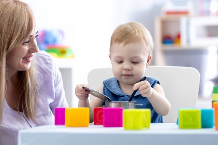 Baby with mom play in nurseryの写真素材