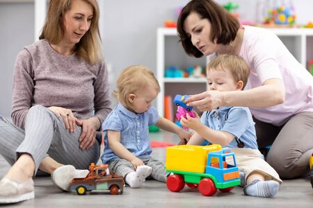 Group of happy moms with their babies in nurseryの写真素材