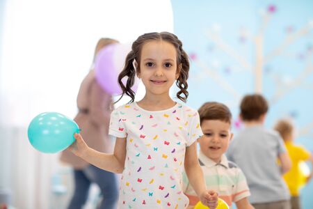 Kid girl with balloon on children party backgroundの写真素材