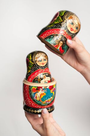Russian matryoshka bright, symbol of Russia in the women hands on a white backgroundの写真素材