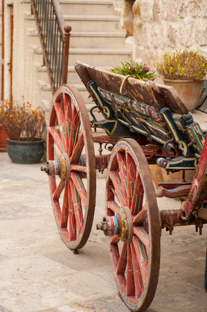 old cart bright red color in the yard of the old townの写真素材