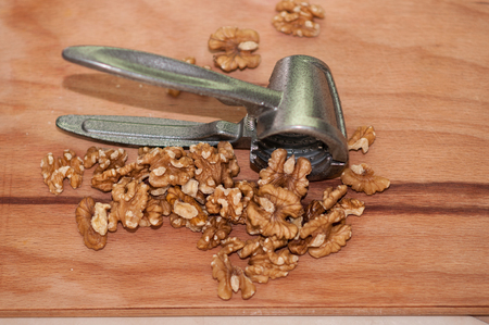 tongs for chopping walnuts and shelled walnut close upの写真素材