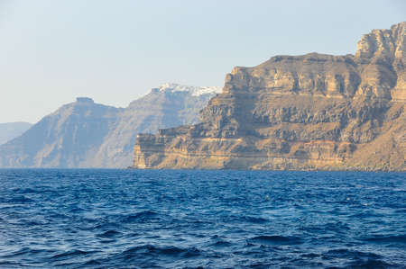 Brigantine in the Mediterranean Sea against the backdrop of the cliffs and Santorini Islandの写真素材
