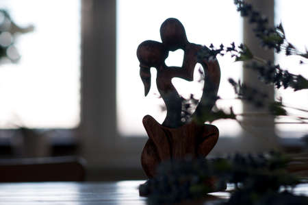 A figurine in the form of two men kissing a man and a woman against a background of flowers. A symbol of love. The concept of Valentines Day.の写真素材