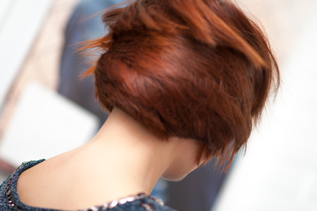 Accurate geometric shape short haircut on a woman with red hair in detailの写真素材
