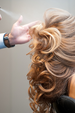 Process of evening creating hairstyles for a girl with long blond hair by a master hairdresser at a beauty marathon in Chelyabinsk, Hotel Redisson Blue, December 2, 2018の写真素材