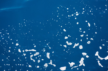sea blue water with foam close upの写真素材