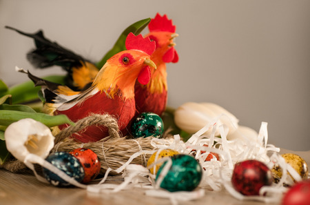 Easter eggs, two hens in a nest and white tulips bright background image
