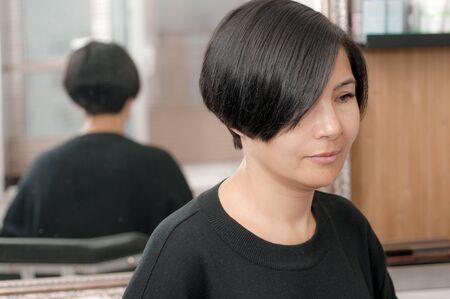 Woman with dark hair and a short haircut in a beauty salonの写真素材