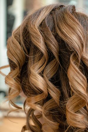 Long brown hair curled the process of creating a hollywood hairstyle close-up