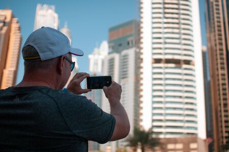 men photographs the modern tall buildings of the city during the dayの写真素材