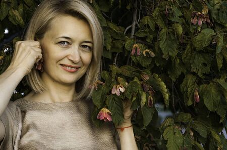 Middle-aged blond woman with a smile in a  park