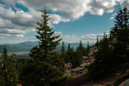 Beautiful landscape with a mountain range on a blue sky with white clouds on the forest meadows and lake in summer Russia, Chelyabinsk region, Zyuratkul Rangeの写真素材