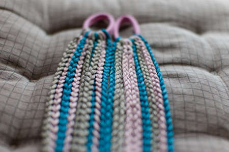 Colored braids made of pink and blue artificial hair on a hand-made cutter close-upの写真素材