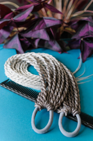 Accessory for long hair from small colored braids with an elastic hair band in assortment on a wooden tableの写真素材