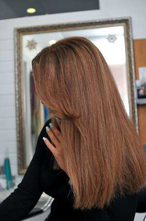 Woman with beautiful long brown hair in profile in a beauty salonの写真素材