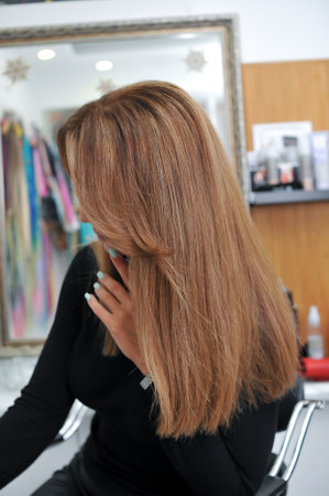 Woman with beautiful long brown hair in profile in a beauty salonの写真素材