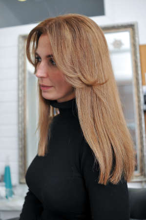 Woman with beautiful long brown hair in profile in a beauty salonの写真素材