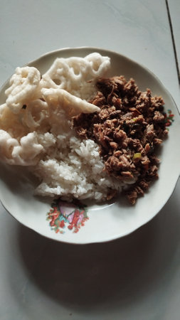 A plate of rice with ground beef cooked with curry spices and topped with crackers. Simple food that is delicious and full of nutritionの写真素材