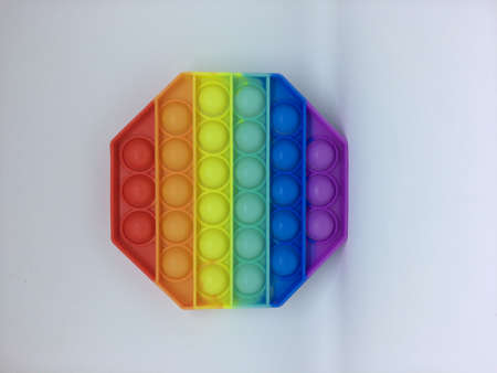 Rainbow Pop it fidget toy isolated on a white background. Fidget popper, anti anxiety and stress relief gameの写真素材