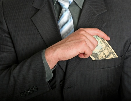 Businessman putting a dollar bill in his pocket
