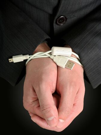 Businessman hands tied with an USB cableの写真素材