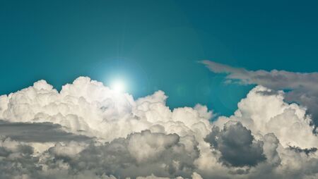 Blue sky, white and gray clouds and bright sunの写真素材