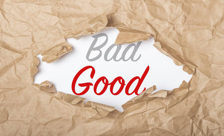 Good and bad words on white paper with copy space and torn cardboxの写真素材