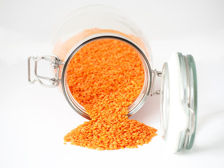 Glass jar of red lentils on white backgroundの写真素材