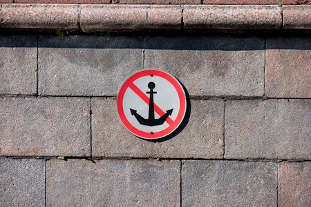 Round river mooring prohibited sign on the granite facing of the canal bankの写真素材