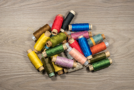Sewing thread reels on a wood textured background.の写真素材