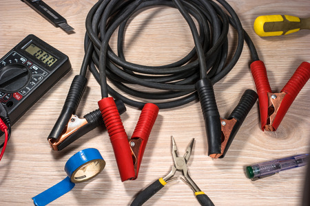 Cables for batteries and electrical tools on wood background.の写真素材