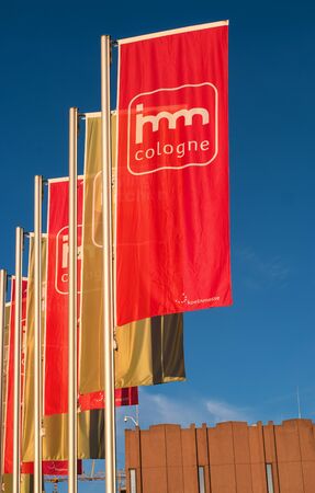 Cologne, Germany - January 22, 2017: imm Cologne - international exhibition of furniture and interior design. Flags at the main entrance to the exhibition Koelnmesse. Flags at imm company colors - red and gold.のeditorial素材