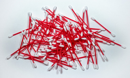 Cotton swabs stacked randomly. Red plastic sticks nicely contrasts on a light background.の写真素材