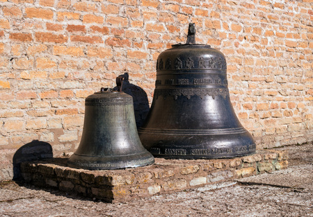 Narva, Estonia - March 16, 2017: Traditional old church bells in Narva citadel. The surface is decorated with inscriptions and decorations.のeditorial素材