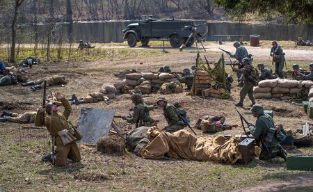 Gatchina, Russia - May 7, 2017: Historical reconstruction of the battles of World War II. German soldiers defend a mortar battery. The dead Soviet soldier falls.のeditorial素材