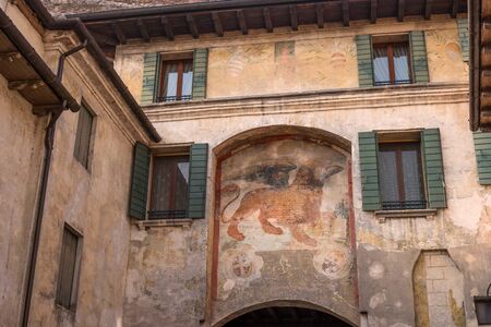 An ancient fresco of a Venetian lion on the wall of a house in Canegliano. The winged lion of St. Mark is a symbol of the city of Venice and one of the elements of the flag of the Italian fleet.の写真素材