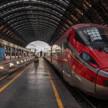 Venice, Italy - 08 May 2018: High-speed train Trenitalia at the train station of Milan. A worker is going along the platform on an electric vehicle. The platform has an openwork metal archのeditorial素材