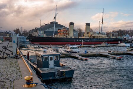 Tallinn, Estonia - November 18, 2018: Suur Toll icebreaker at the pier. The icebreaker steamer is part of the Tallinn Maritime Museum. Hangars of the Maritime Museum in the backgroundのeditorial素材