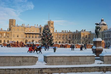 Gatchina, Russia - January 5, 2019: Gatchina Palace, New Year's Fair on the parade ground. People walk around the fair. Children ride a camel. Photo taken in the evening.のeditorial素材