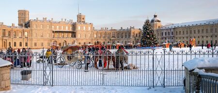 Gatchina, Russia - January 5, 2019: New Year and Christmas Fair on the parade ground of the Gatchina Palace. In the center is a decorated Christmas tree. Horse harnessed to the sleigh.のeditorial素材