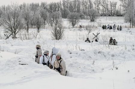 St. Petersburg, Russia - January 19, 2019: Military historical reconstruction - the battle for Leningrad. Trenches of the German army. Soldiers in white camouflage coats. Calm before the fightのeditorial素材