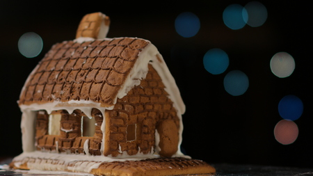 Gingerbread house with blue lights bokeh circles blur Christmas garland Happy New Yearの写真素材